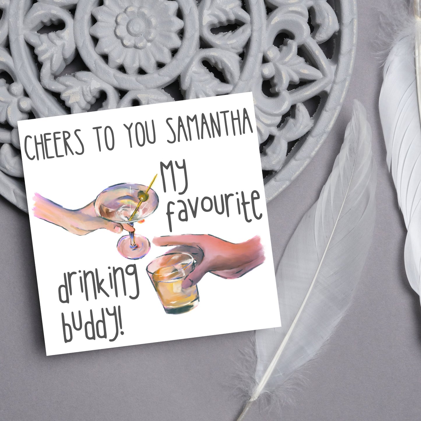 Square card with watercolour design of 2 hands holding drinks glasses against a white background, with grey text that reads "cheers to you Samantha, my favourite drinking buddy"