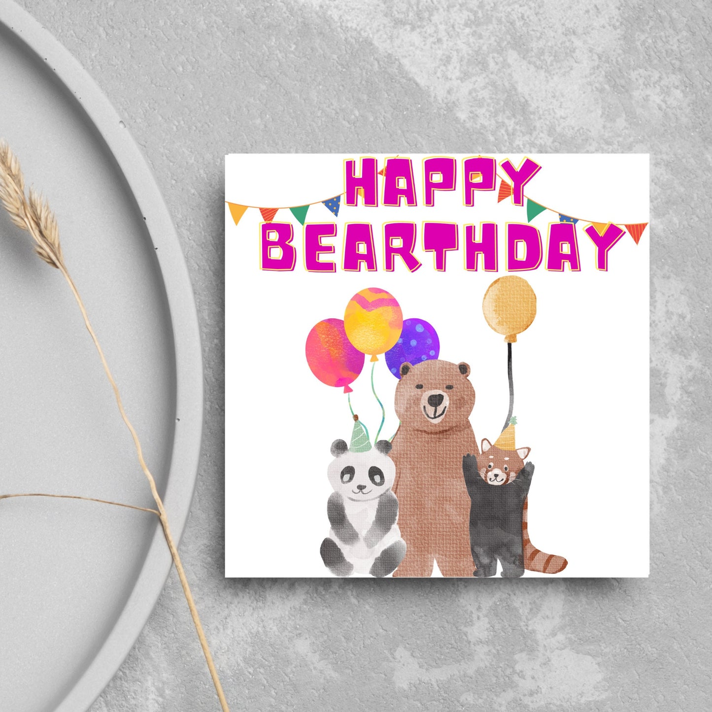 Image of a square Birthday Card. The card has a white background with a vibrant watercolour illustration of 3 bears holding balloons and big pink text that reads happy bearthday, a cute play on the traditional happy birthday.