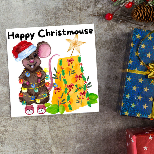 Square Christmas card featuring a cartoon mouse wrapped in christmas lights and wearing a santa hat and slippers next to a christmas tree made from cheese with decorations of holly and red bows. The text, Happy Christmouse is written at the top