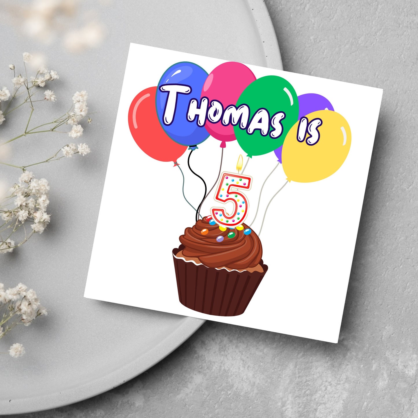 square childs birthday card with chocolate cupcake design personalised with name balloons and a number 5 candle. card reads thomas is 5