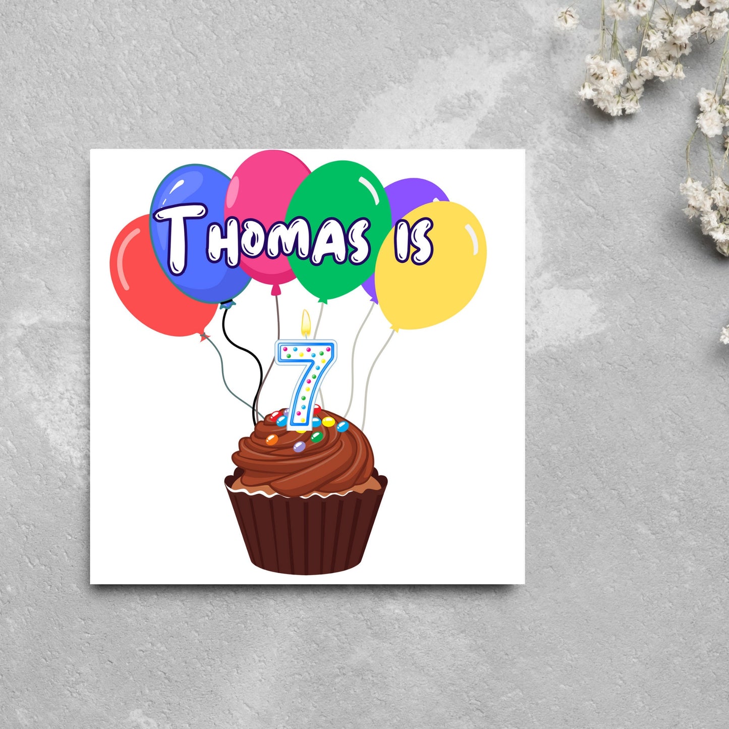 square childs birthday card with chocolate cupcake design personalised with name balloons and a number 7 candle. card reads thomas is 7
