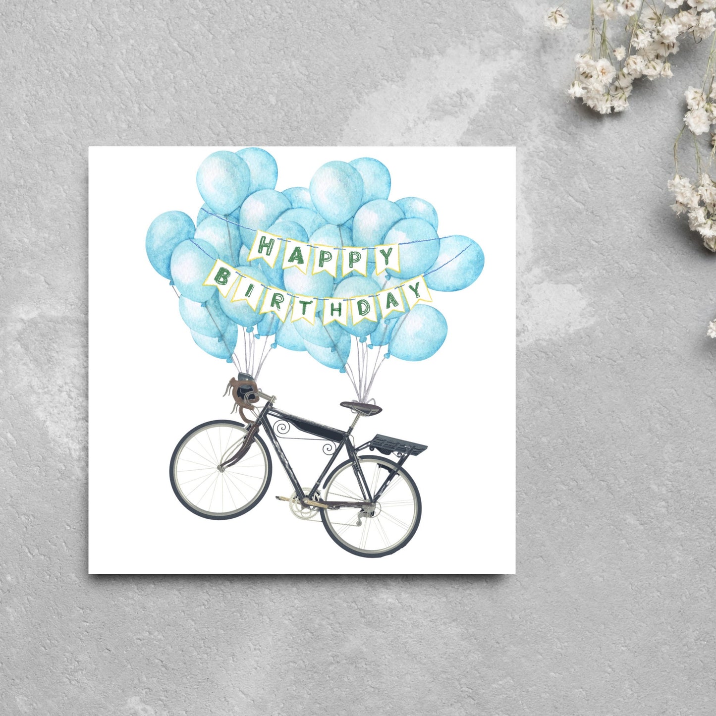 White square birthday card with an illustration of a bicycle being held aloft by blue watercolour balloons and bunting that reads happy birthday