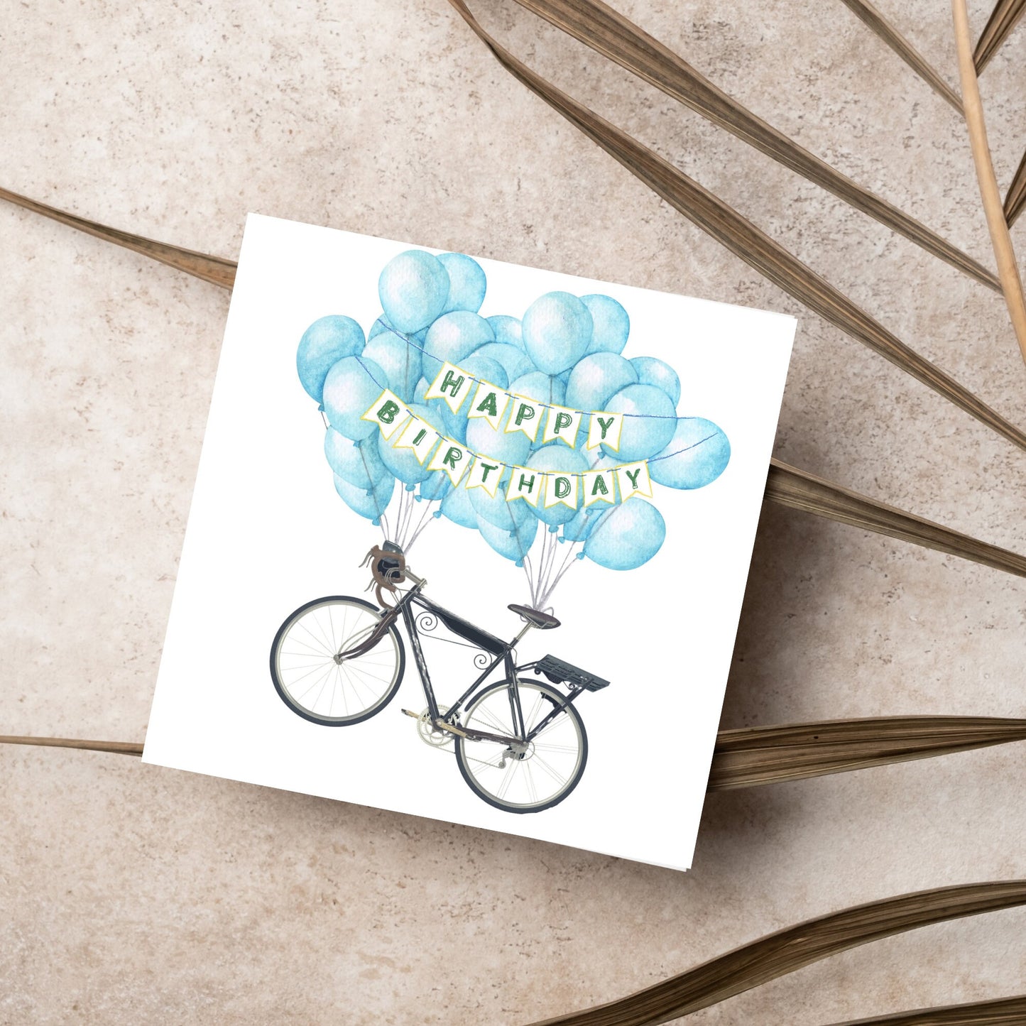 White square birthday card with an illustration of a bicycle being held aloft by blue watercolour balloons and bunting that reads happy birthday