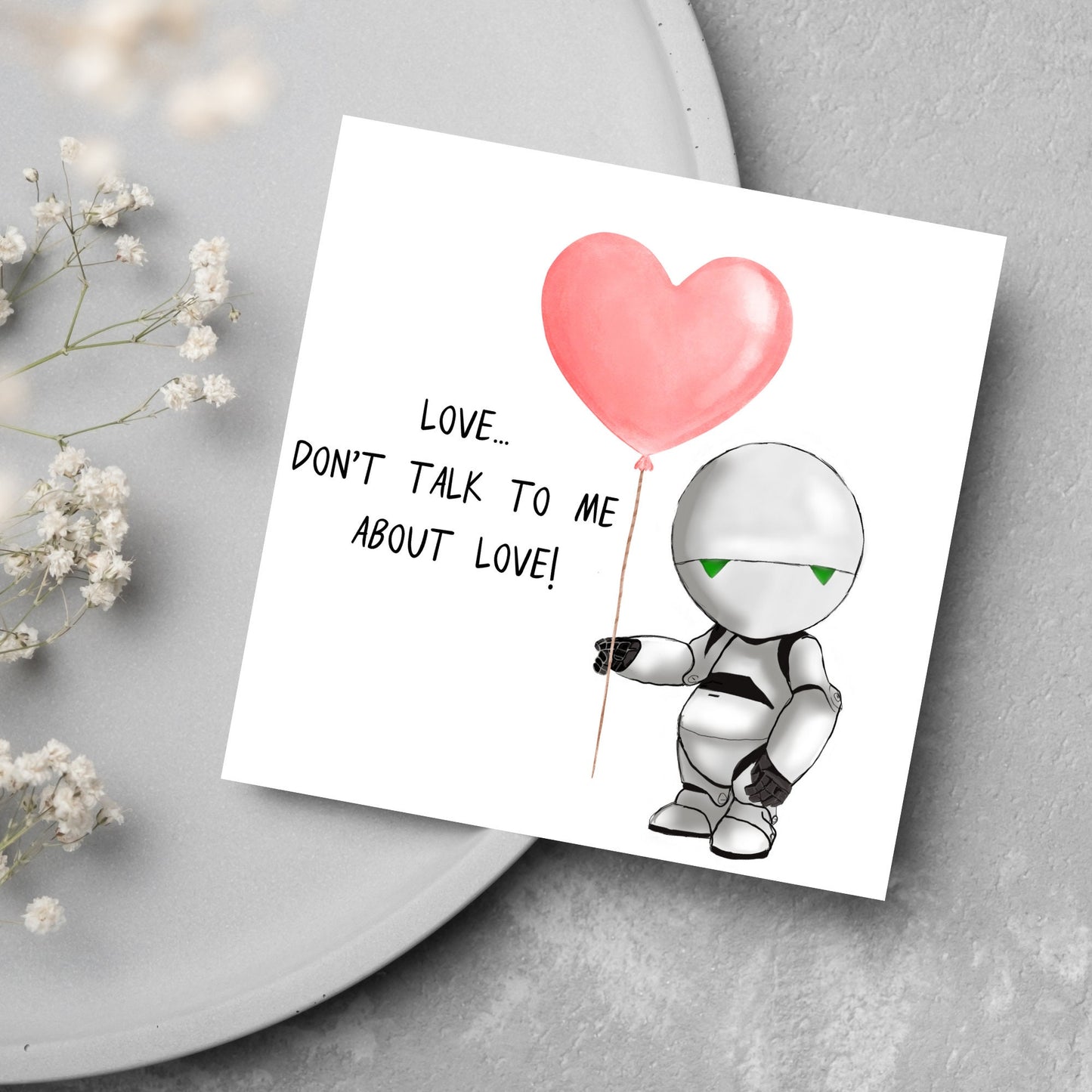 The Square Card has an illistration of Marvin from the classic book, a Hitchhikers guide to the galaxy holding a heart shaped Balloon. It is accompanied by the caption "Love, dont talk to me about Love!"
Funny Love card for boyfriends