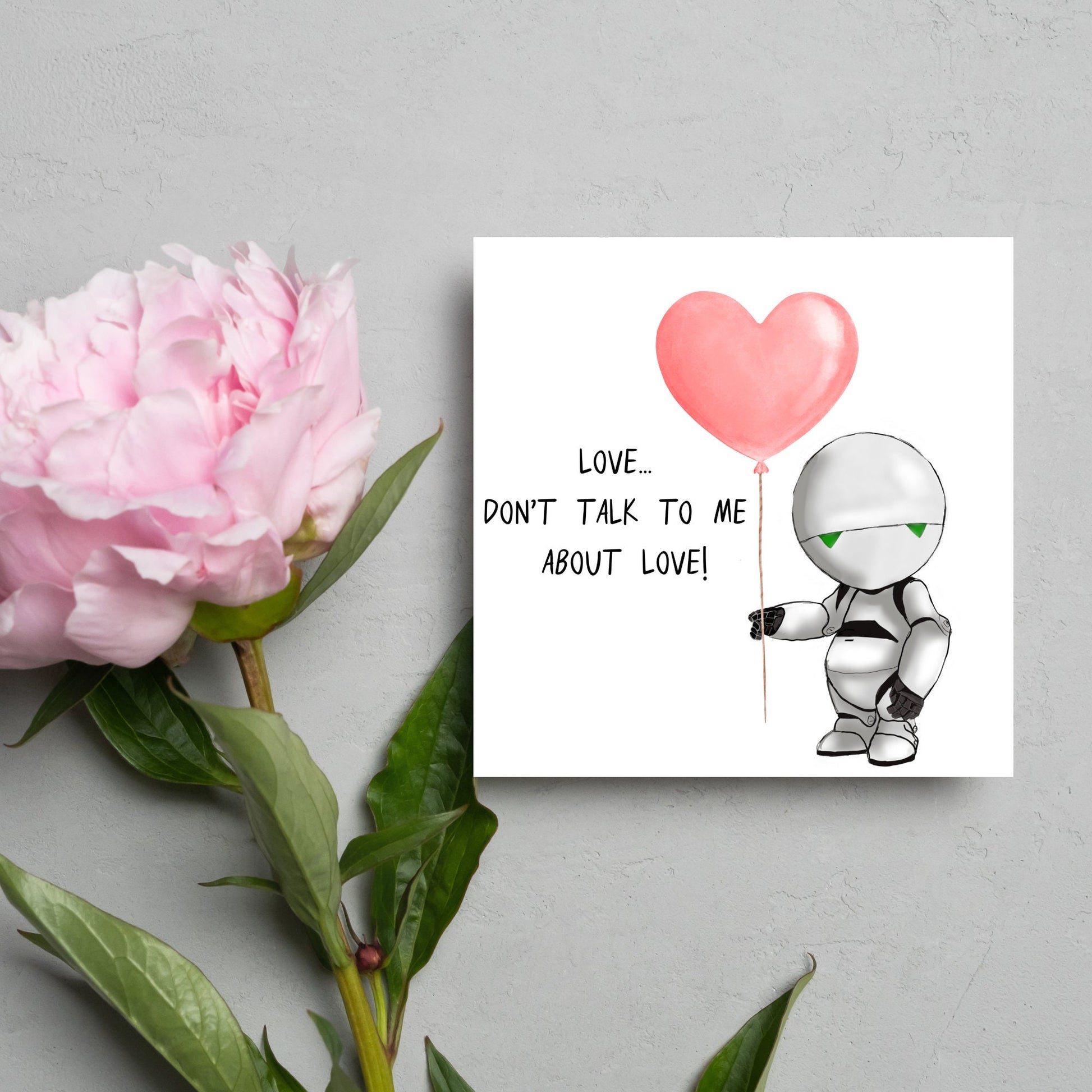 The Square Card has an illistration of Marvin from the classic book, a Hitchhikers guide to the galaxy holding a heart shaped Balloon. It is accompanied by the caption "Love, dont talk to me about Love!"
Funny Love card for boyfriends