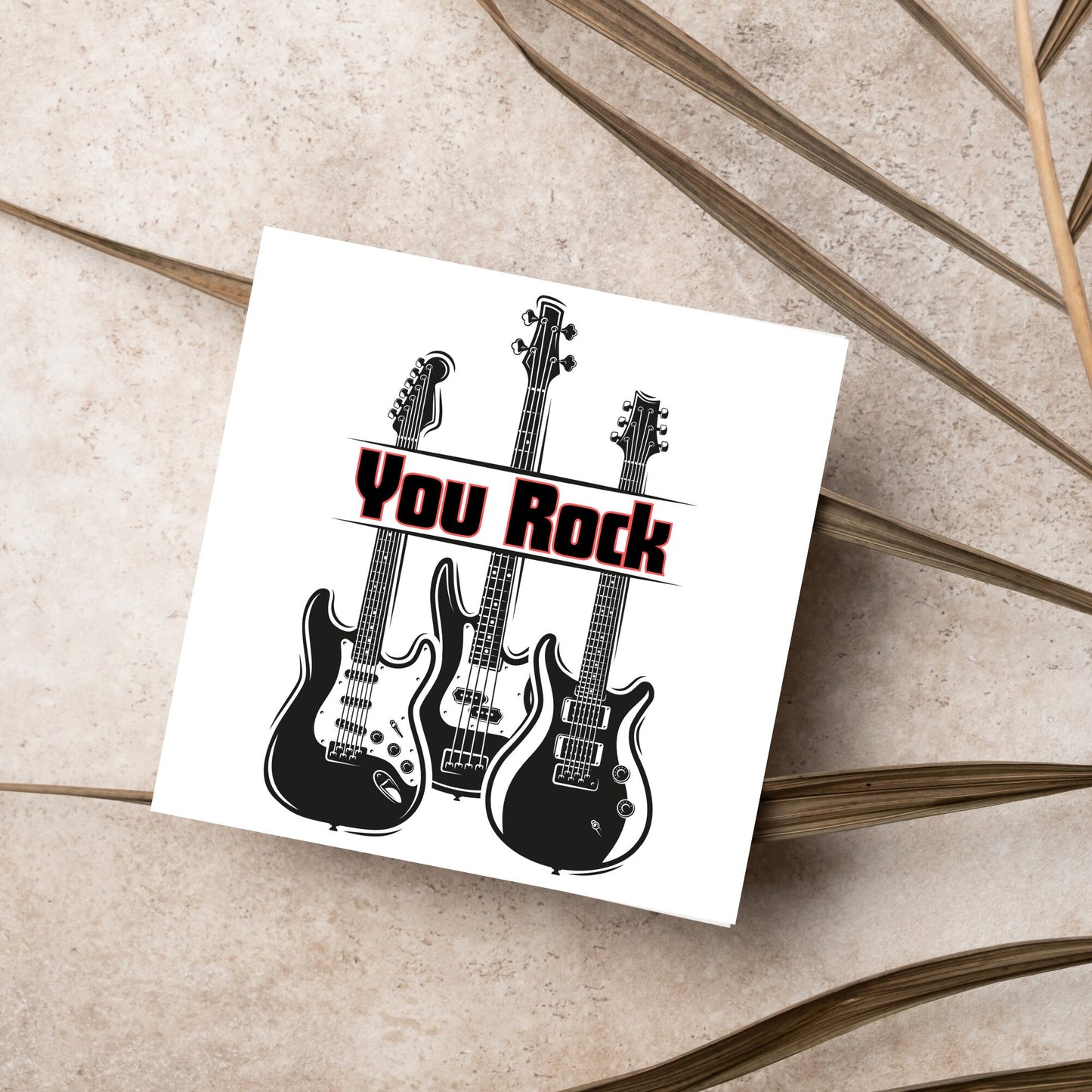 Square Greetings card featuring 3 black electric guitars with 'you rock' written across them in red and black