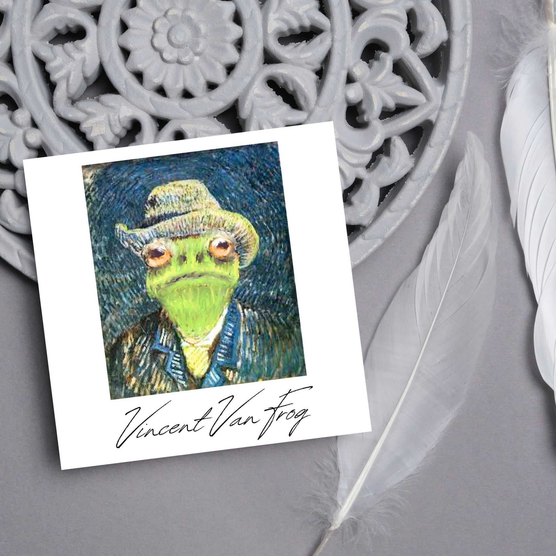 Image of a square greetings card with a remake of Vincent Van Gogh's famous self portrait but redone into a frog face. Underneath the painting the text reads Vincent Van Frog in a signature style