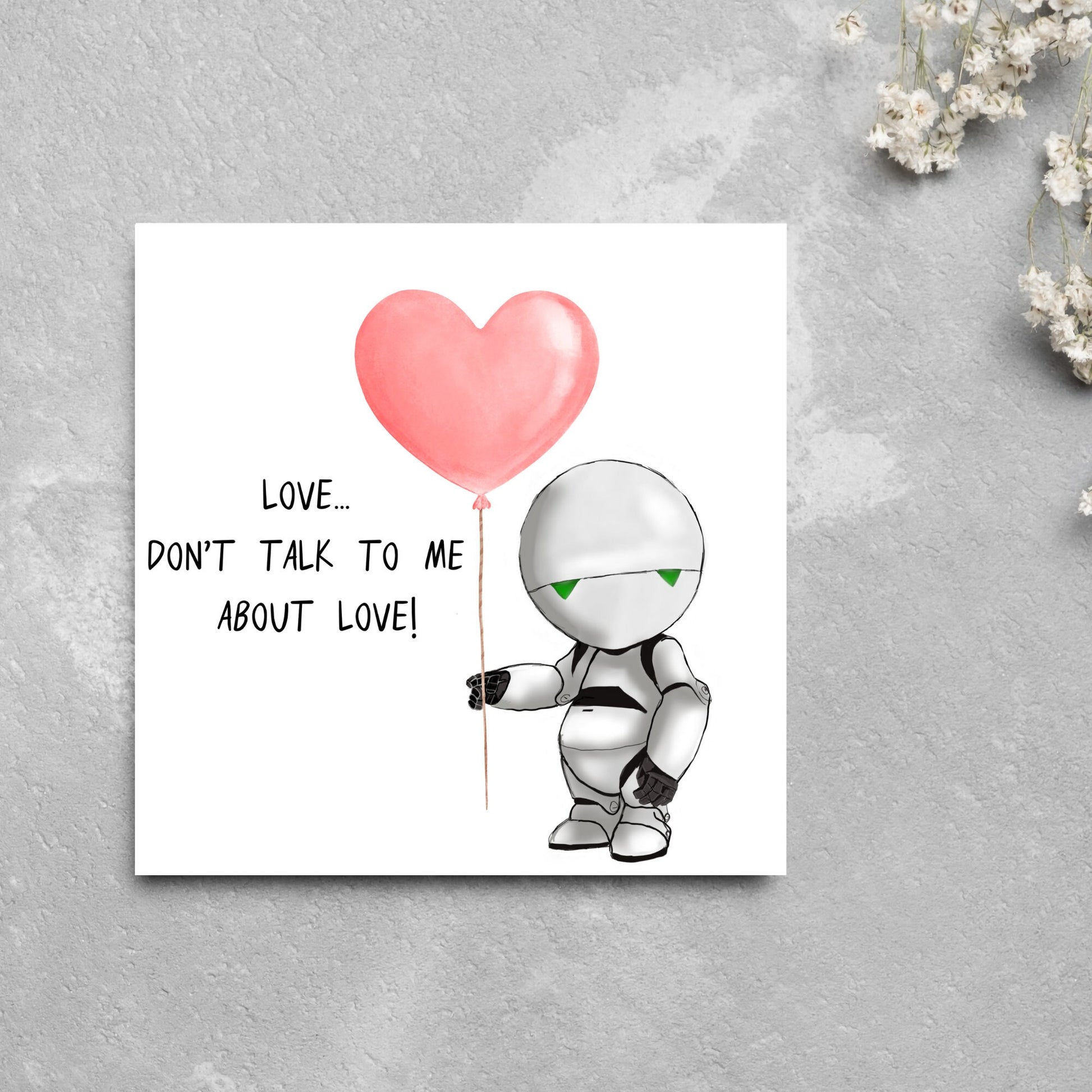 The Square Card has an illistration of Marvin from the classic book, a Hitchhikers guide to the galaxy holding a heart shaped Balloon. It is accompanied by the caption "Love, dont talk to me about Love!"
Funny Love card for boyfriends