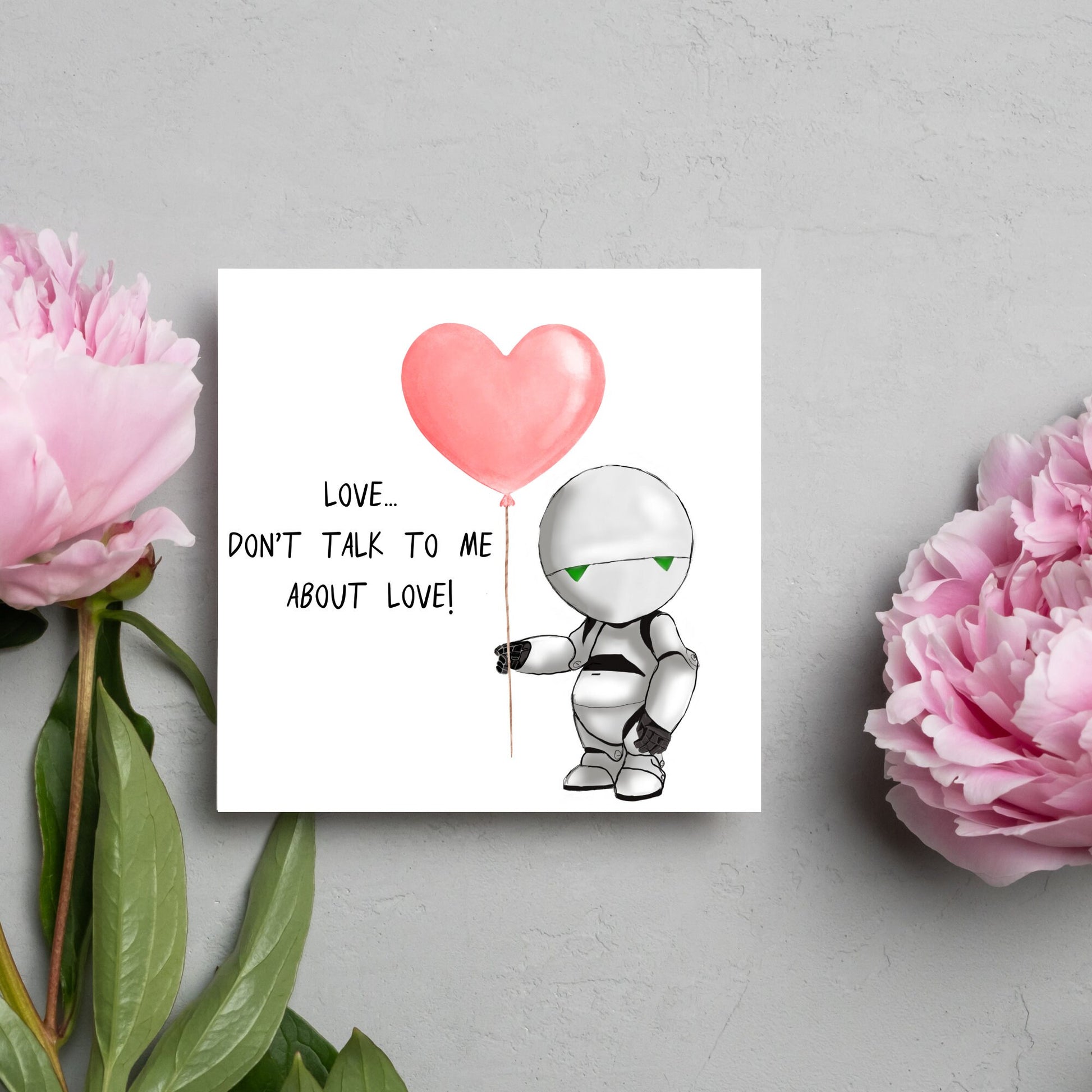 The Square Card has an illistration of Marvin from the classic book, a Hitchhikers guide to the galaxy holding a heart shaped Balloon. It is accompanied by the caption "Love, dont talk to me about Love!"
Funny Love card for boyfriends