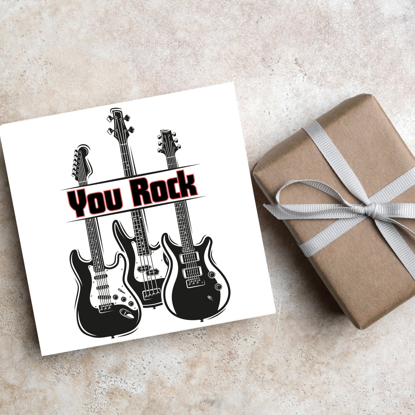 Square Greetings card featuring 3 black electric guitars with 'you rock' written across them in red and black