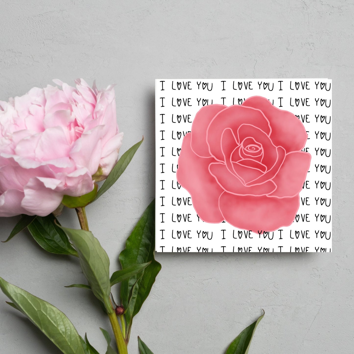 simple elegant card for valentines or anniversary, featuring a large pink rose painting with a background of handwritten style text that repeats 'I love you' with hearts instead of o's