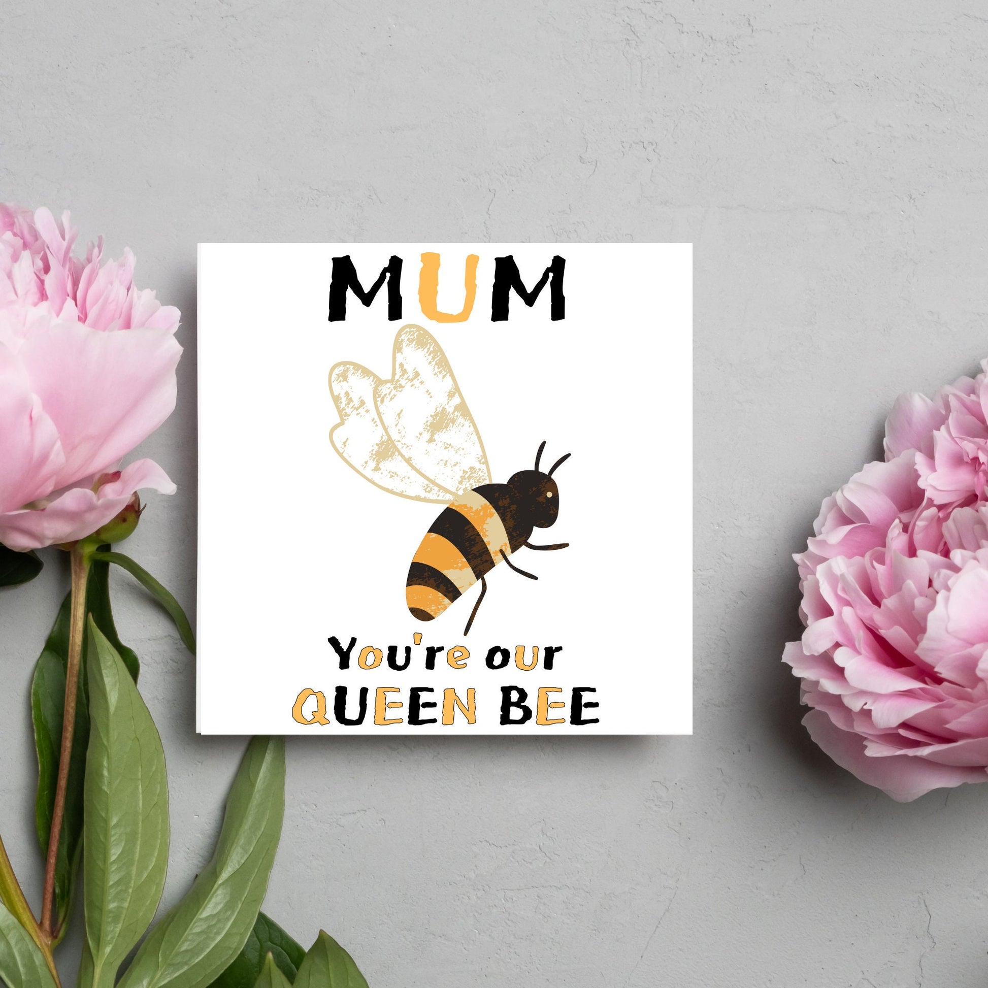 square Birthday card with a watercolour illustration of a bee in the centre and yellow and black text which reads , mum youre our queen bee, in a textured style font resembling pollen