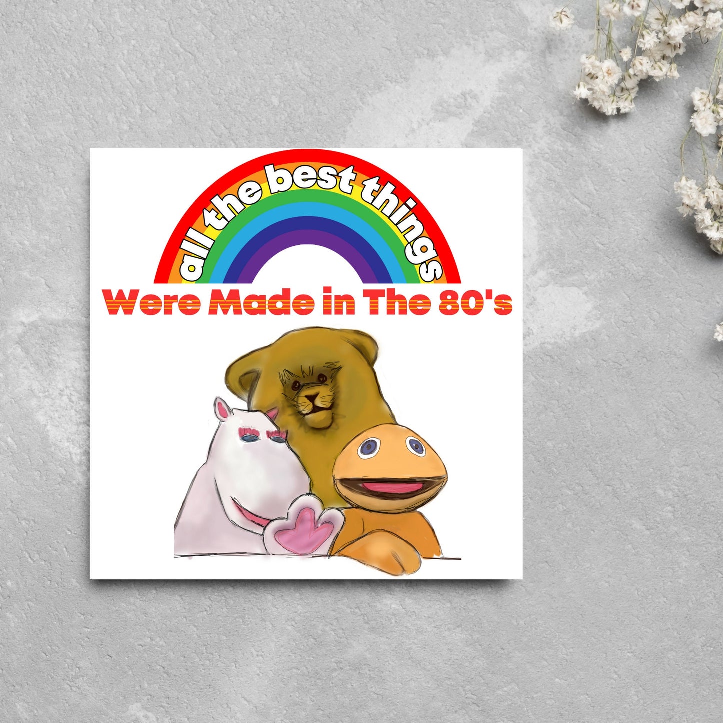 square card featuring an illustration of the characters from the tv show rainbow with a rainbow and red text that reads 'all the best things were' made in the 80's' in the font from the shows title