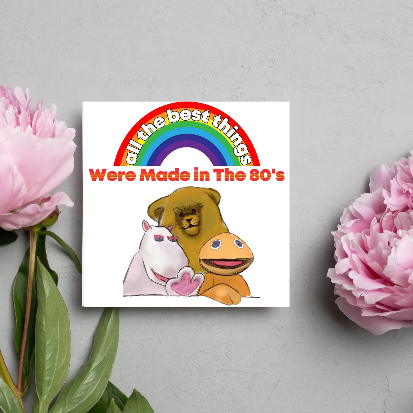 square card featuring an illustration of the characters from the tv show rainbow with a rainbow and red text that reads 'all the best things were' made in the 80's' in the font from the shows title