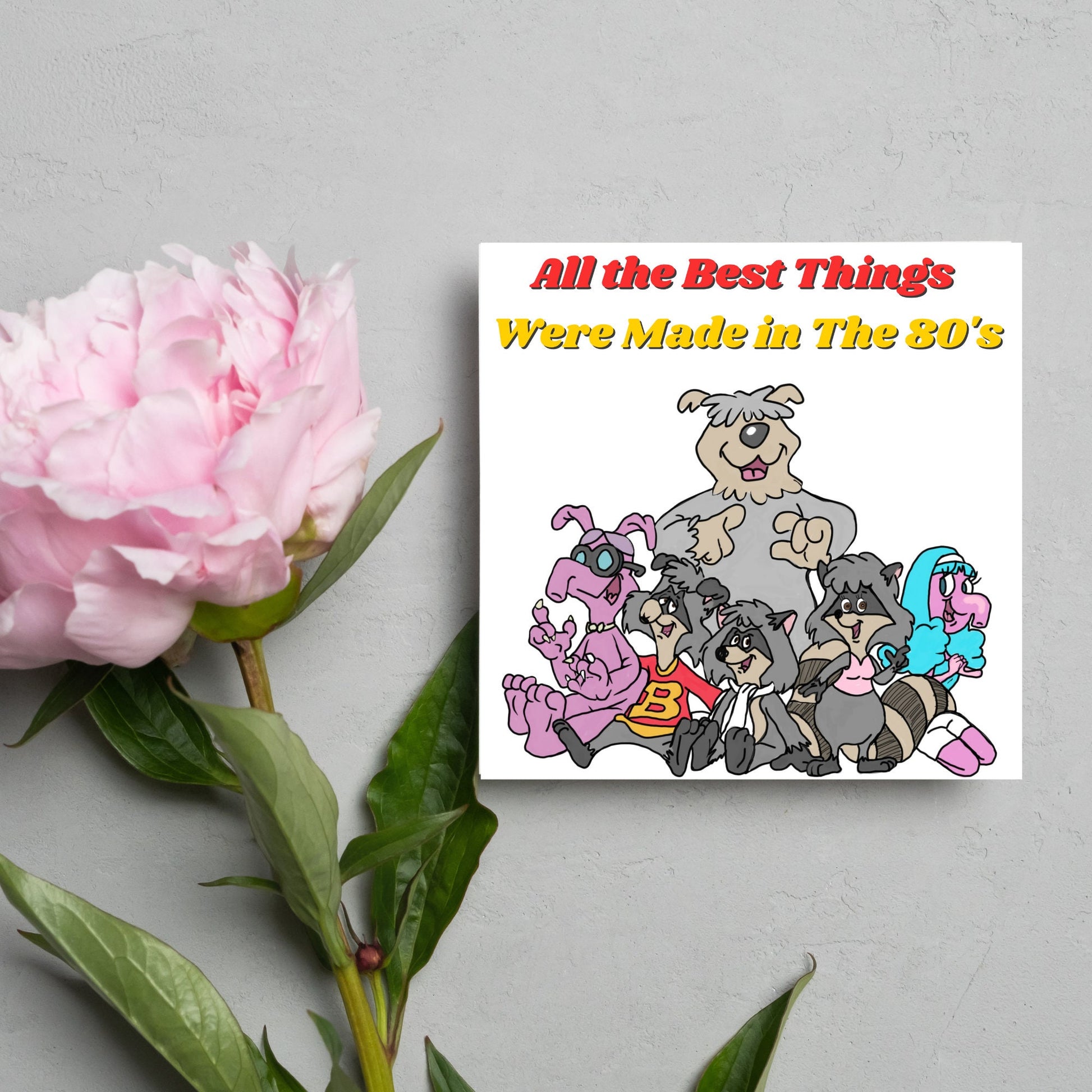square card featuring an illustration of the raccoons from the tv cartoon with yellow and red text that reads  'all the best things were' made in the 80's' in the font from the shows title