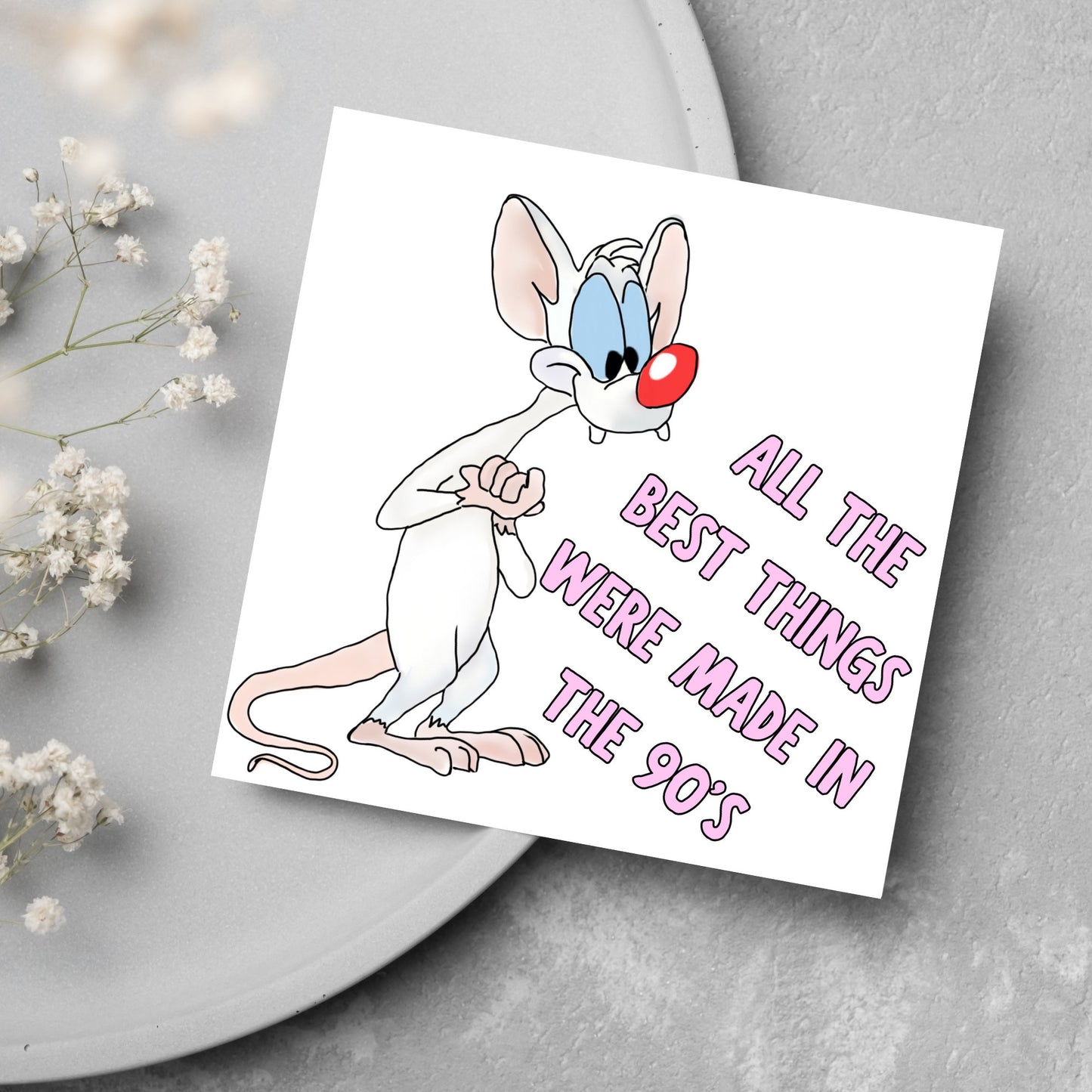 square card featuring an illustration of Pinky from Pinky and the brain with pink text text that reads 'all the best things were' made in the 90's' in the font from the shows title