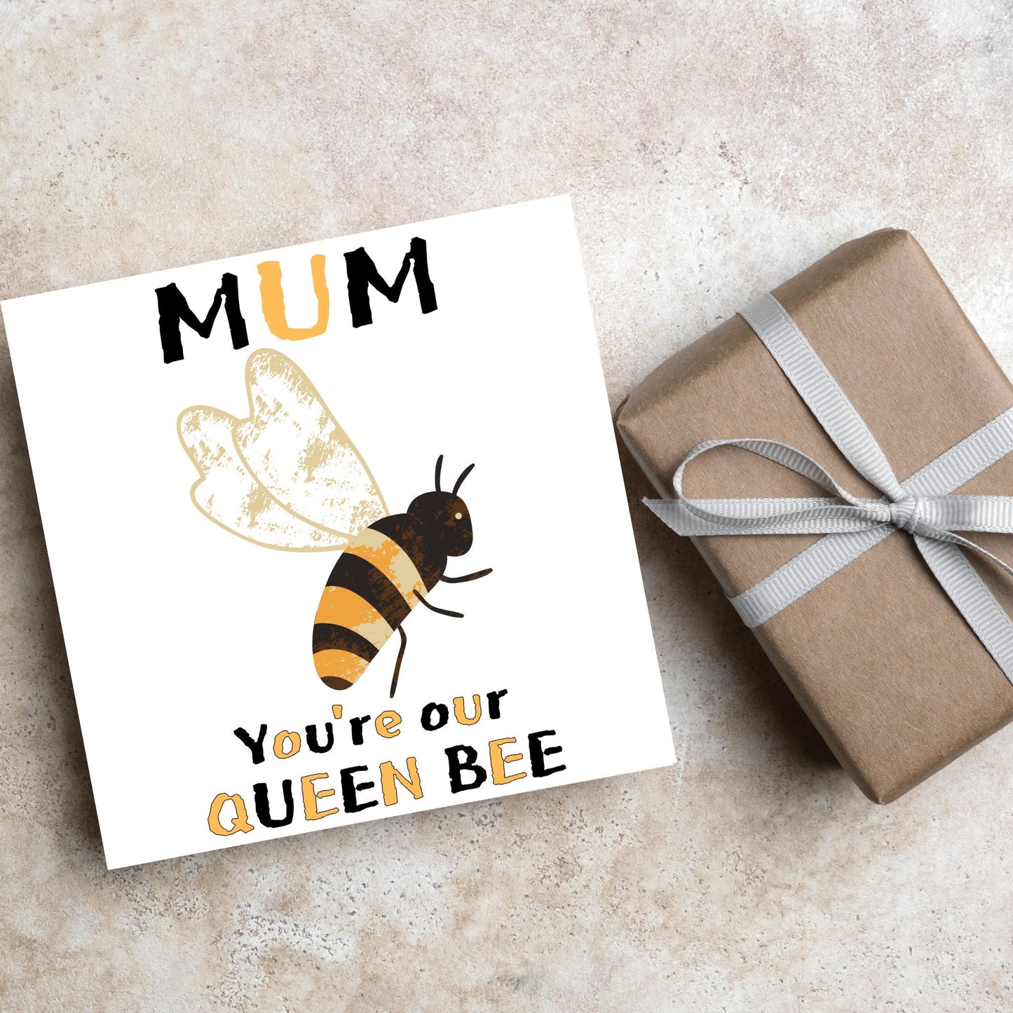 square Birthday card with a watercolour illustration of a bee in the centre and yellow and black text which reads , mum youre our queen bee, in a textured style font resembling pollen