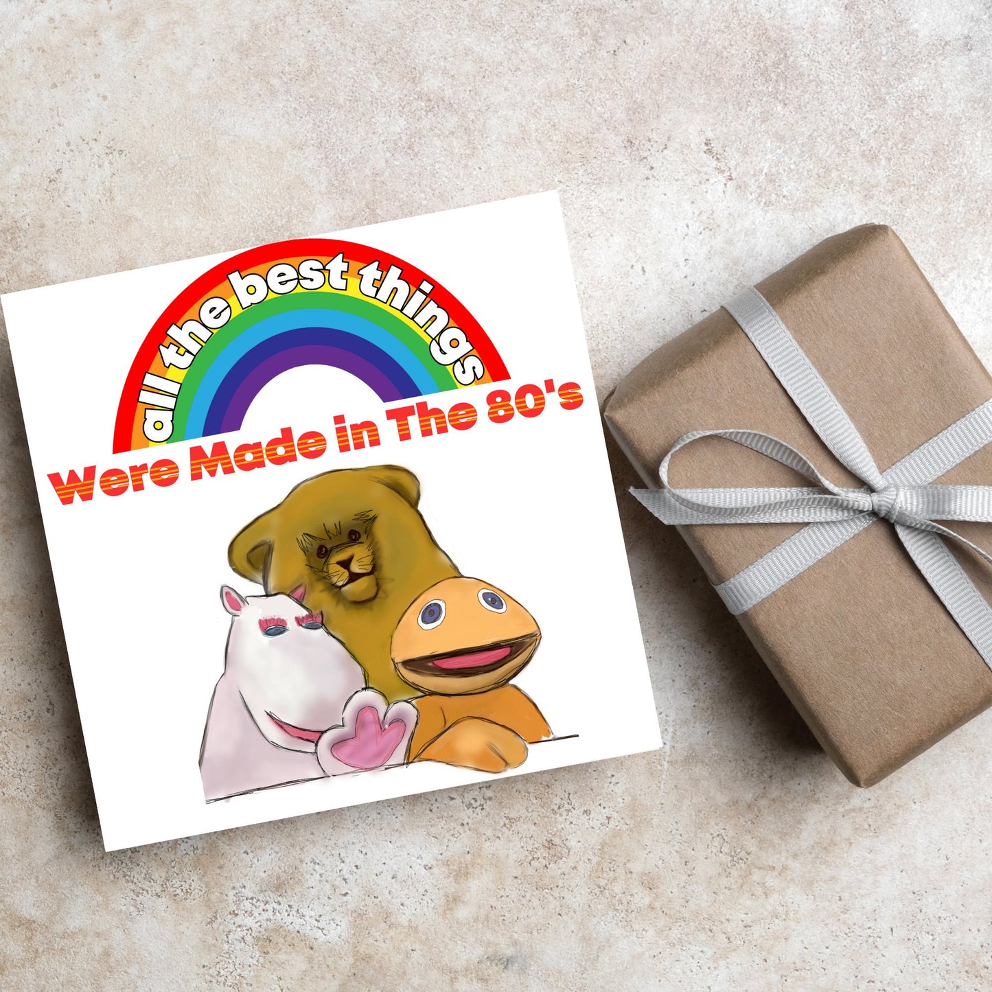 square card featuring an illustration of the characters from the tv show rainbow with a rainbow and red text that reads 'all the best things were' made in the 80's' in the font from the shows title