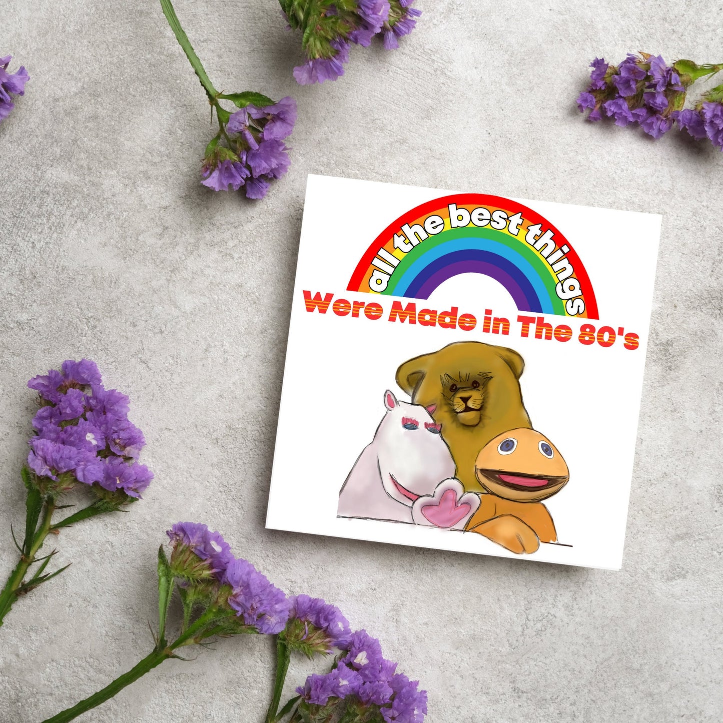 square card featuring an illustration of the characters from the tv show rainbow with a rainbow and red text that reads 'all the best things were' made in the 80's' in the font from the shows title