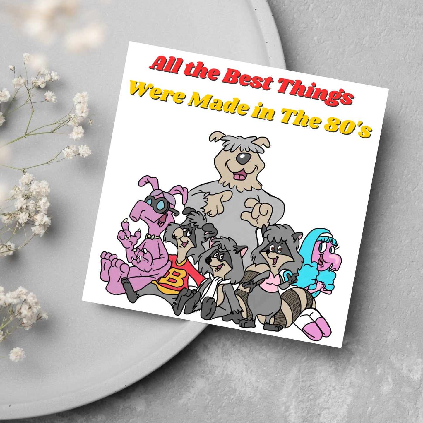 square card featuring an illustration of the raccoons from the tv cartoon with yellow and red text that reads 'all the best things were' made in the 80's' in the font from the shows title