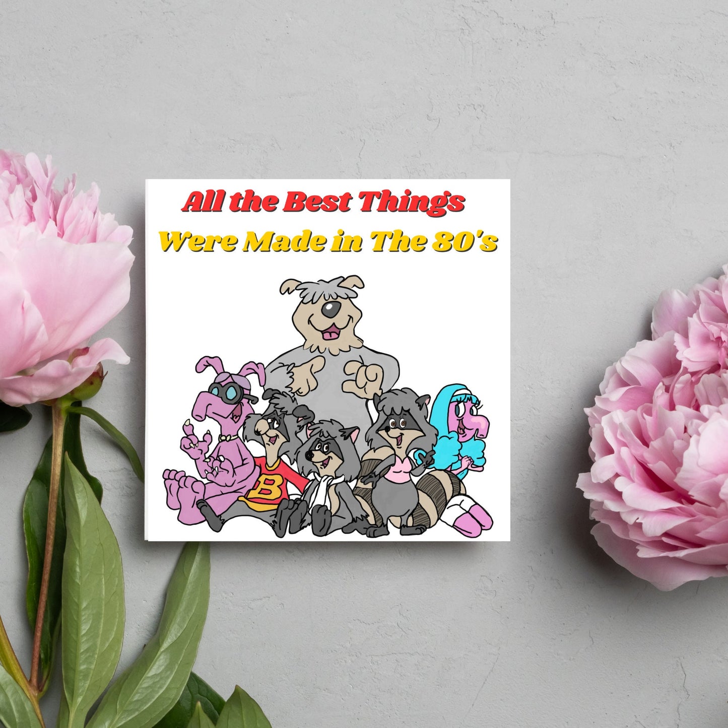square card featuring an illustration of the raccoons from the tv cartoon with yellow and red text that reads 'all the best things were' made in the 80's' in the font from the shows title