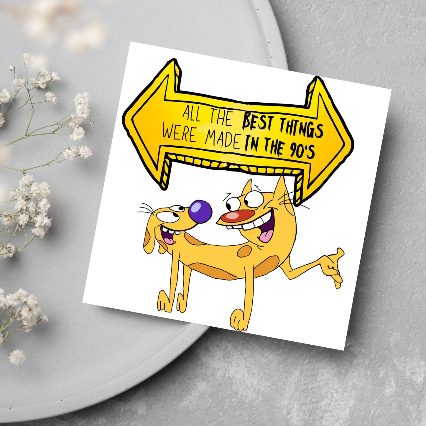 square card featuring an illustration of catdog with a yellow and black sign above them with the text that reads 'all the best things were' made in the 90's' in the font from the shows title