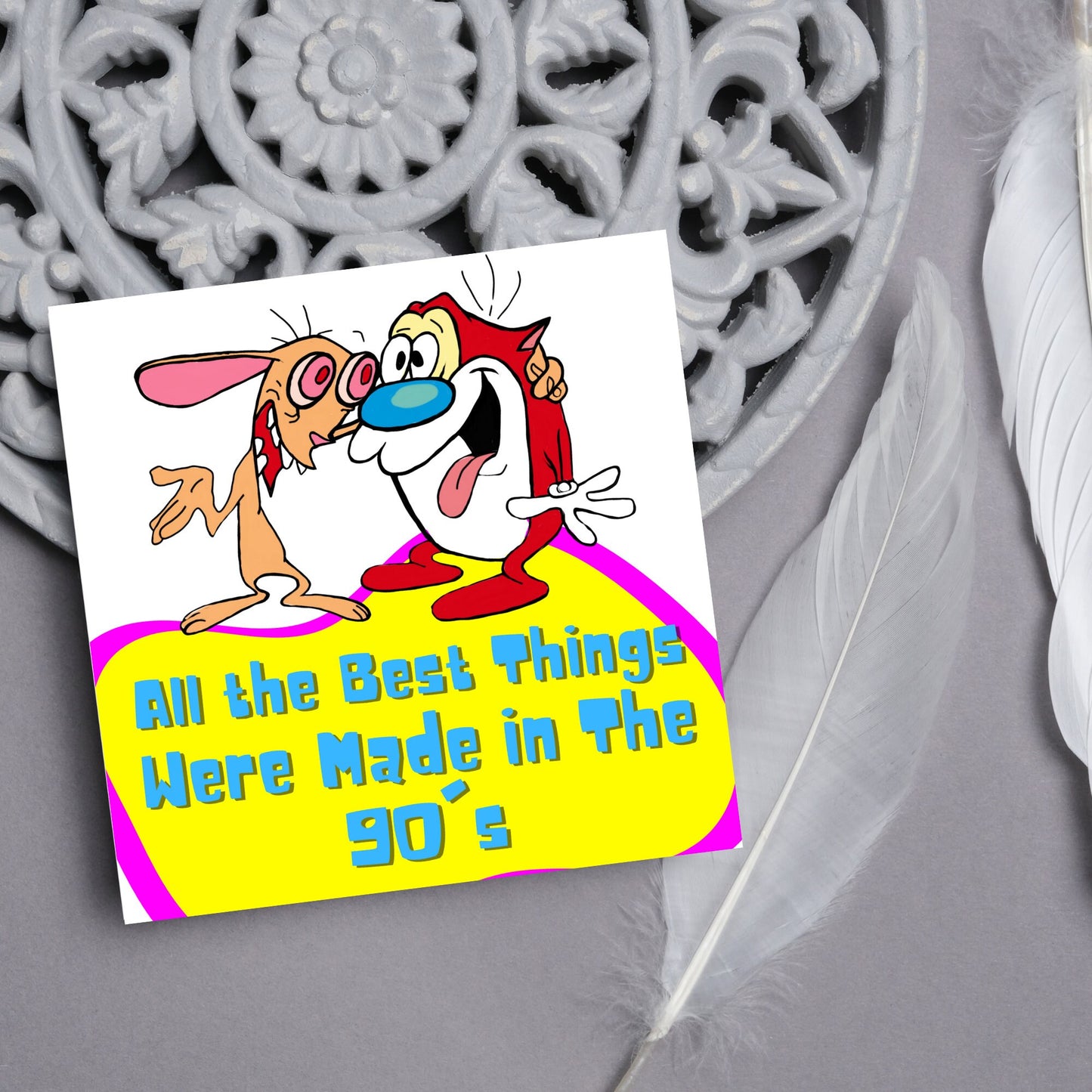 square card featuring an illustration of Ren and Stimpy arm in arm with blue pink and yellow text that reads 'all the best things were' made in the 90's' in the font from the shows title