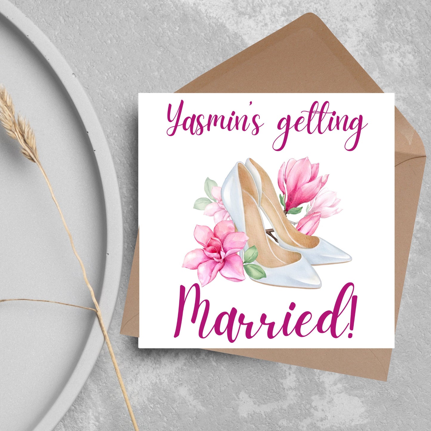 Square card with a watercolour image of white wedding shoes surrounded by pink flowers with pink text that reads Yasmin's getting married in calligraphy style font