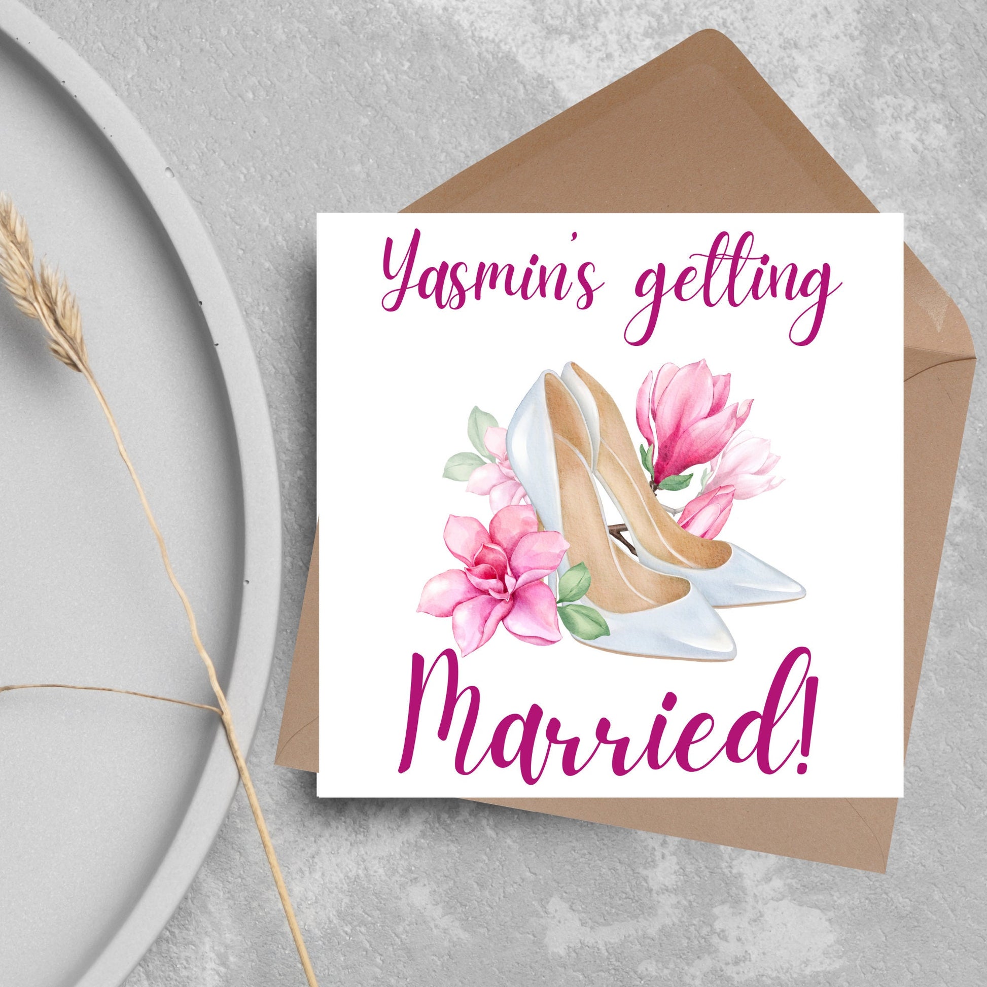 Square card with a watercolour image of white wedding shoes surrounded by pink flowers with pink text that reads Yasmin's getting married in calligraphy style font