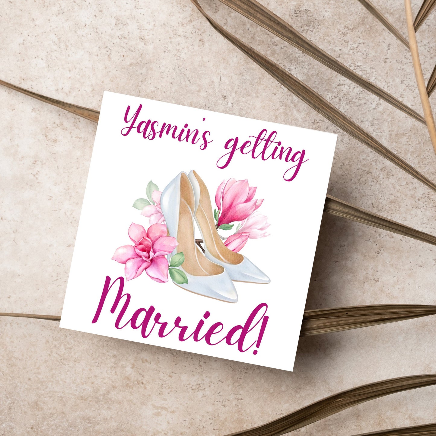 Square card with a watercolour image of white wedding shoes surrounded by pink flowers with pink text that reads Yasmin's getting married in calligraphy style font