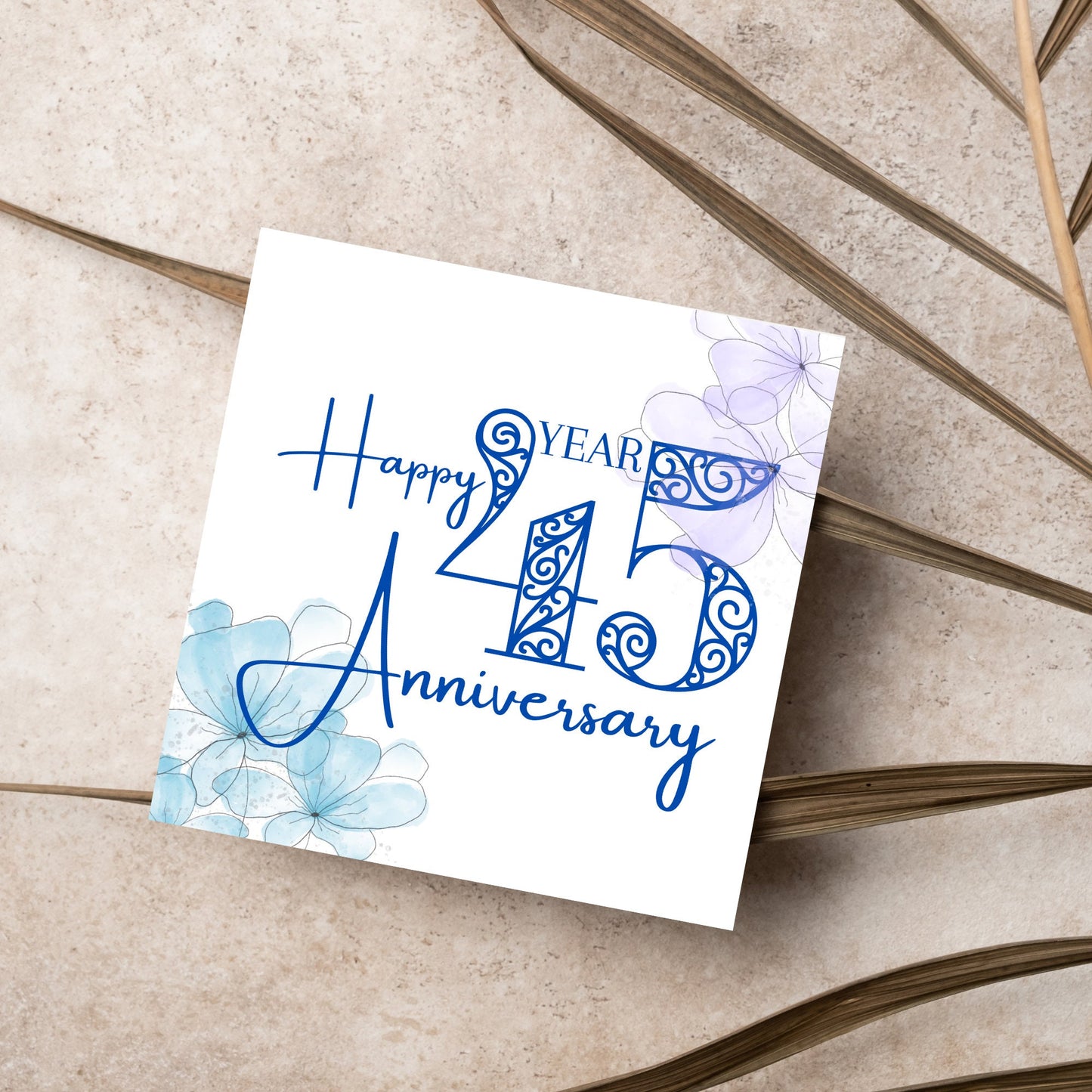 Square Card with white background, there are blue faded watercolour flowers on each corner and dark blue text reads 'Happy 45 year anniversary' the words are in a script font and the number is an ornate filigree style