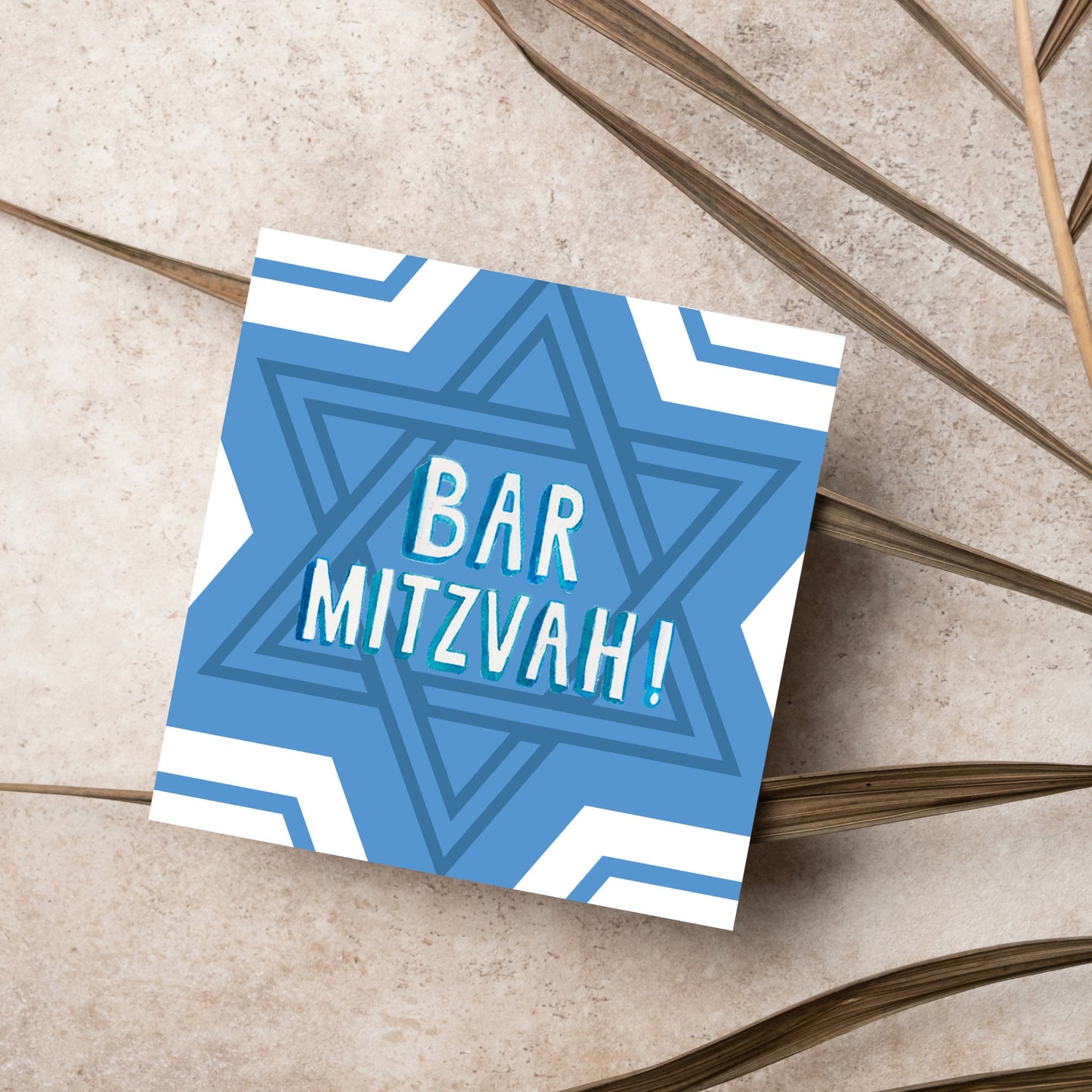 white and blue bar mitzvah card, geometric design with a repeating star of david at the centre in various shades of blue. At the centre of the card in white writing are the words 'bar mitzvah!' in capital letters in a handwritten style font