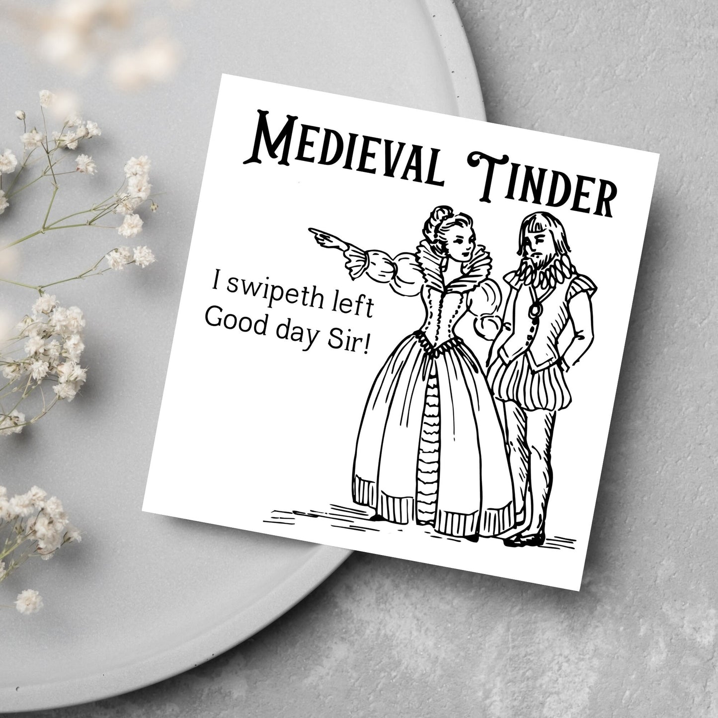 image of a square greetings card with a black and white hand drawn vintage style illustration of medieval man and woman, the woman pointing left and the text - medieval tinder. I swipeth left. Good day Sir! - in a vintage blackletter font