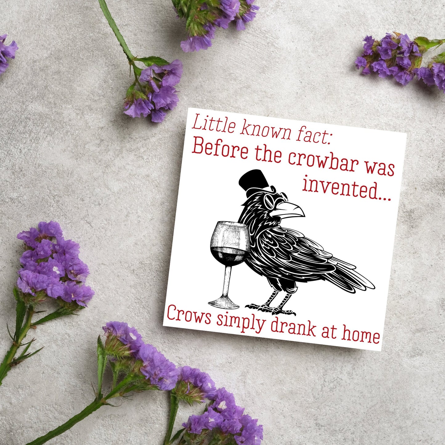 image of a square greetings card with a black and white drawing of a crow wearing a top hat and spectacles, standing next to a half empty glass of wine and the text - little known fact: before the crowbar was invented...crows simply drank at home