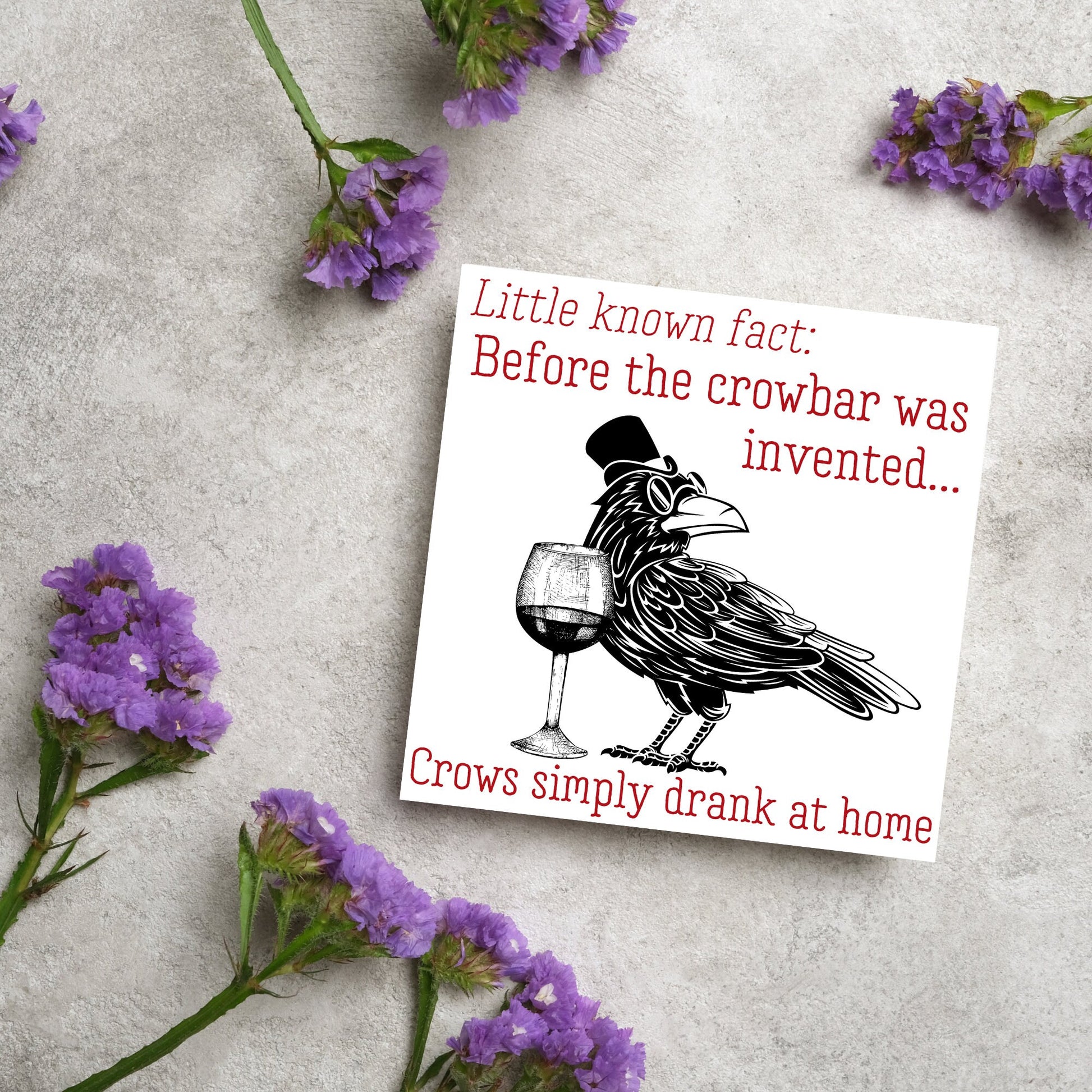 image of a square greetings card with a black and white drawing of a crow wearing a top hat and spectacles, standing next to a half empty glass of wine and the text - little known fact: before the crowbar was invented...crows simply drank at home