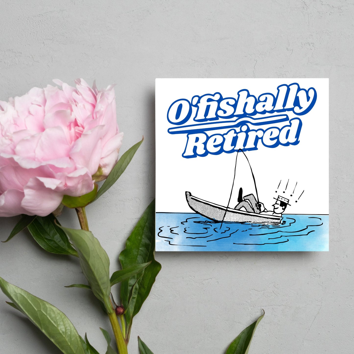 square card with a cartoon of a man in a boat looking happy and relaxed with a fishing rod. big blue and white text reads - ofishally retired'