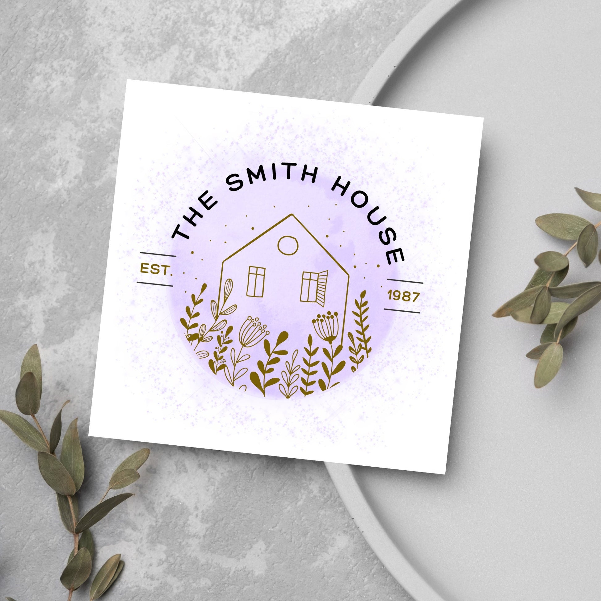 square card with a purple watercolour circle with a line drawing of a house and foliage over it. Arched text reads the smith house on top with est 1987 running through the centre