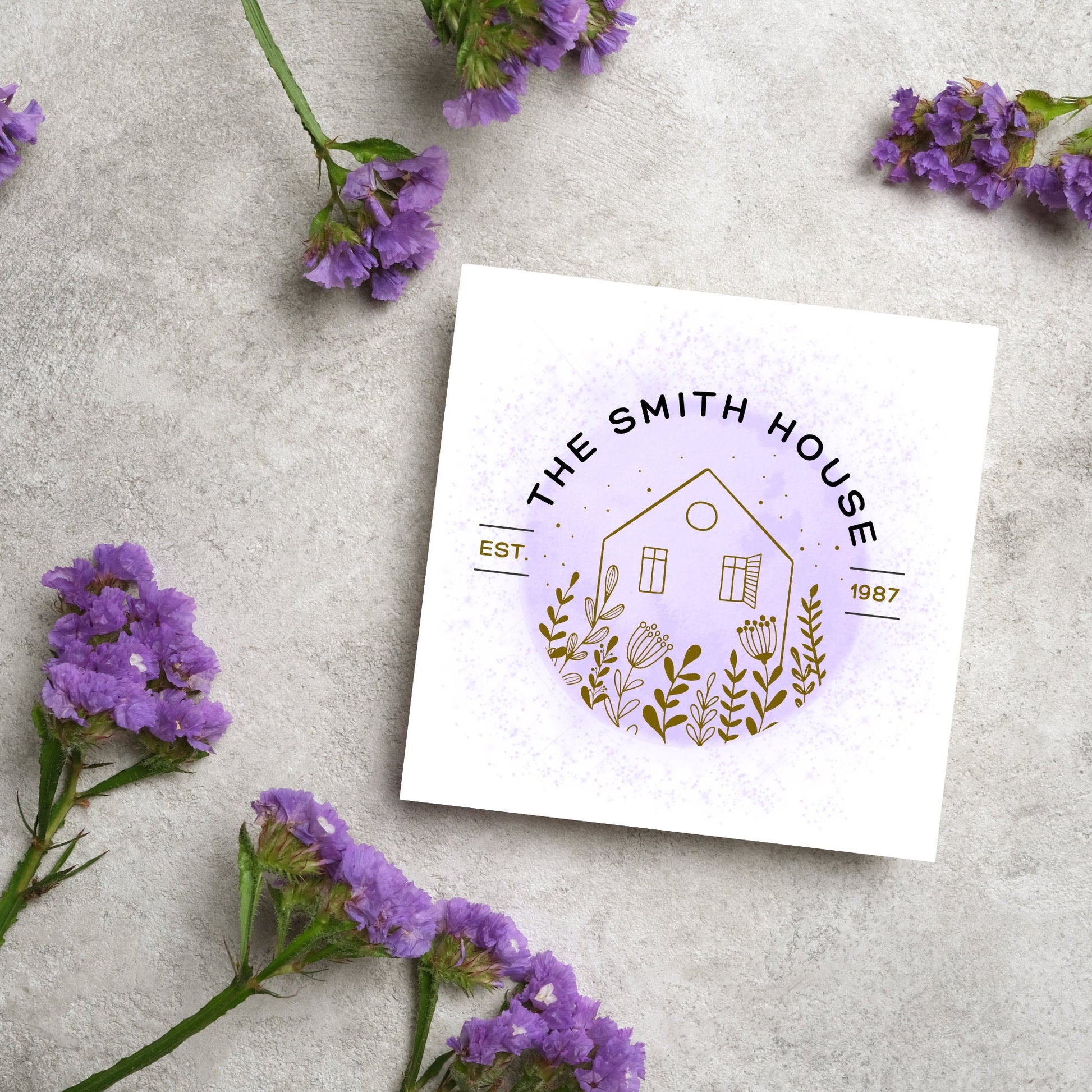 square card with a purple watercolour circle with a line drawing of a house and foliage over it. Arched text reads the smith house on top with est 1987 running through the centre