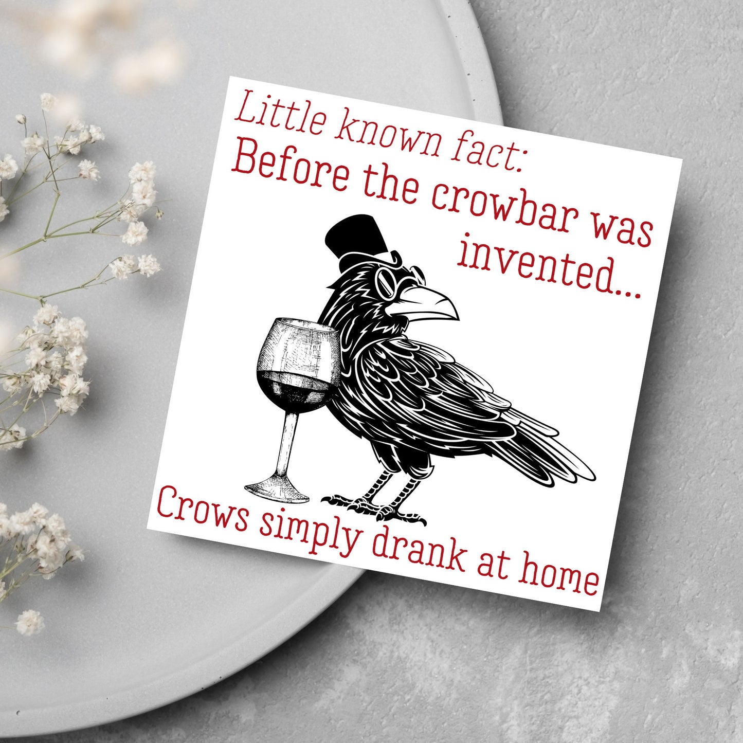 image of a square greetings card with a black and white drawing of a crow wearing a top hat and spectacles, standing next to a half empty glass of wine and the text - little known fact: before the crowbar was invented...crows simply drank at home