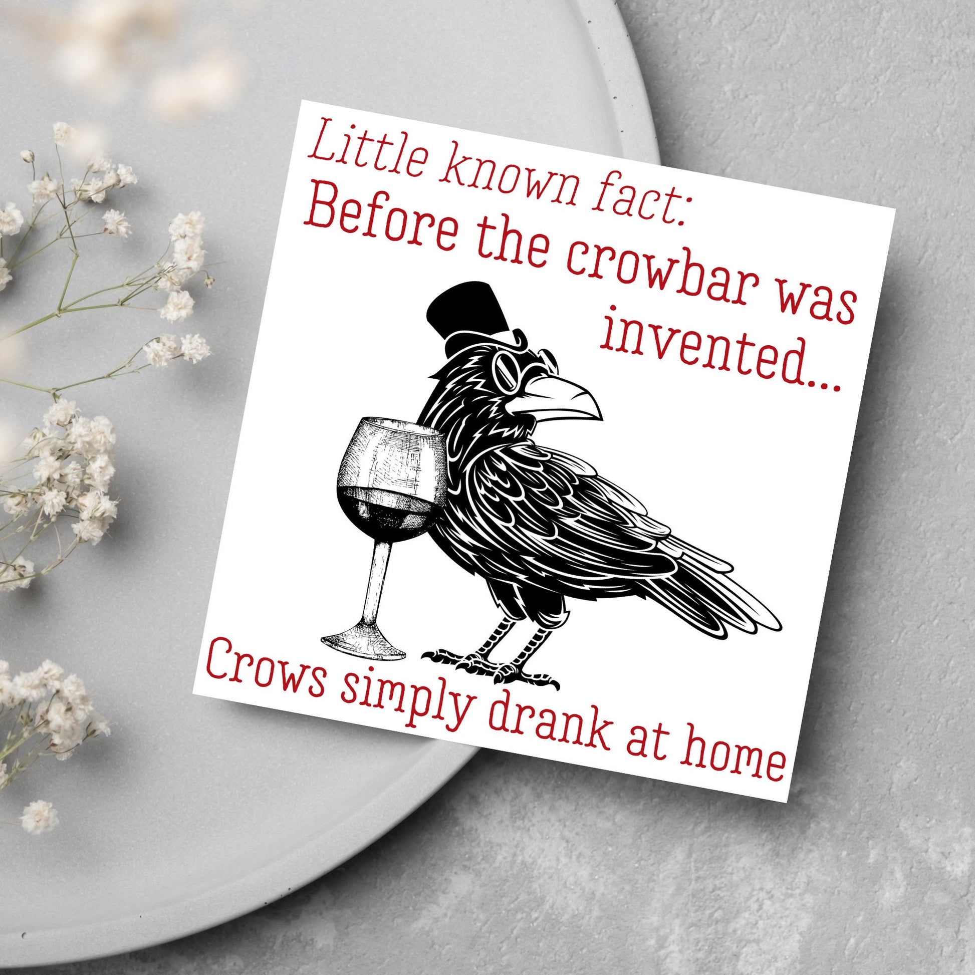 image of a square greetings card with a black and white drawing of a crow wearing a top hat and spectacles, standing next to a half empty glass of wine and the text - little known fact: before the crowbar was invented...crows simply drank at home