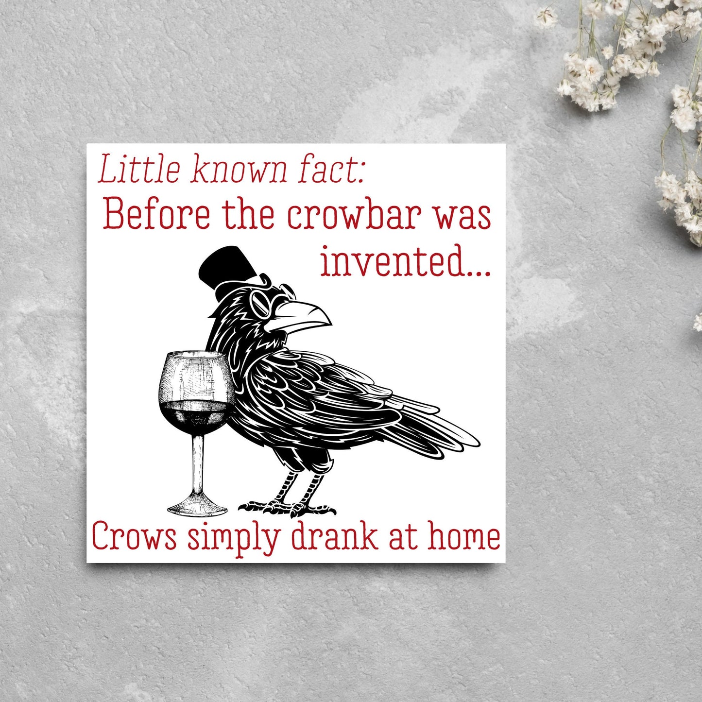 image of a square greetings card with a black and white drawing of a crow wearing a top hat and spectacles, standing next to a half empty glass of wine and the text - little known fact: before the crowbar was invented...crows simply drank at home