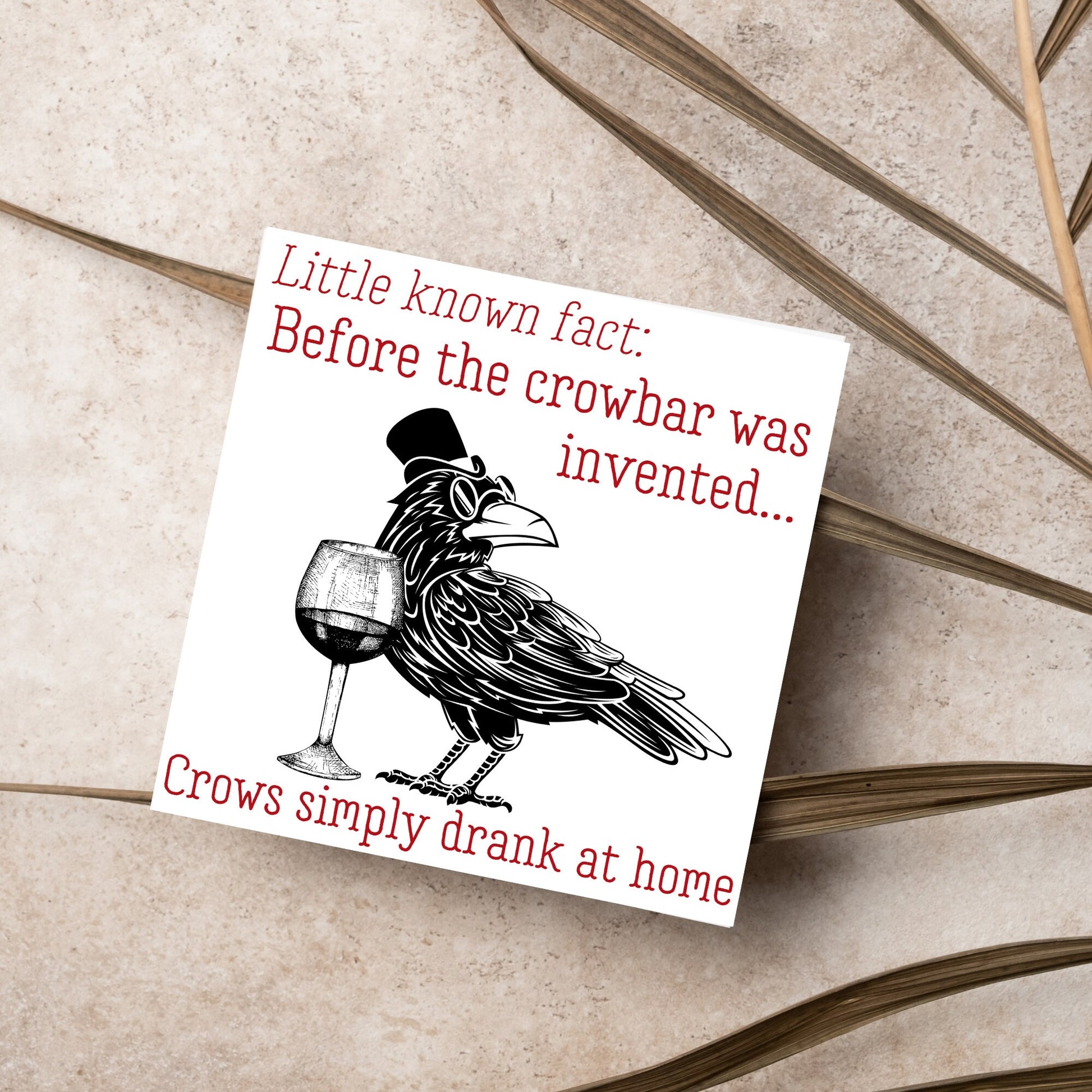 image of a square greetings card with a black and white drawing of a crow wearing a top hat and spectacles, standing next to a half empty glass of wine and the text - little known fact: before the crowbar was invented...crows simply drank at home