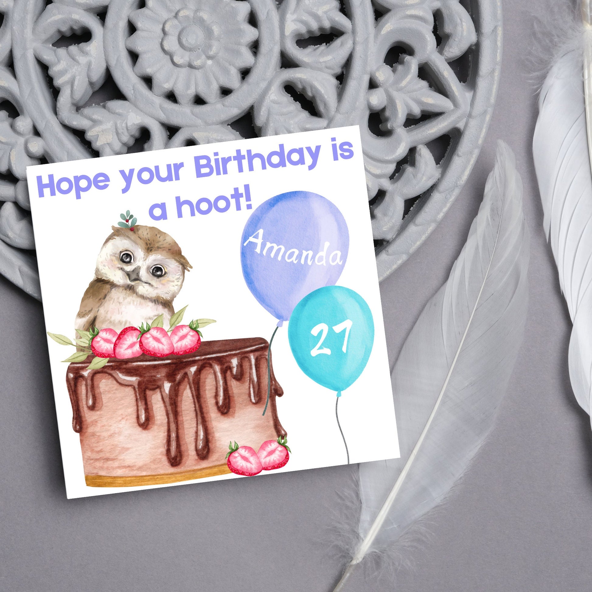 square birthday card with a cute owl sitting on a chocolate cake with the text hope our birthday is a hoot. next to the owl are two blue balloons, one with the name of the person and one with the age in white writing