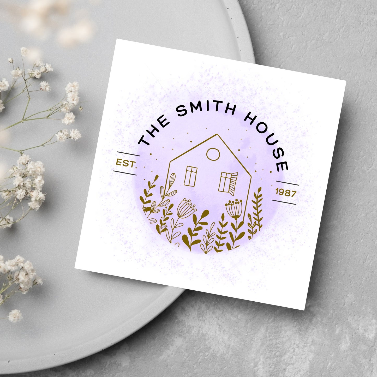 square card with a purple watercolour circle with a line drawing of a house and foliage over it. Arched text reads the smith house on top with est 1987 running through the centre