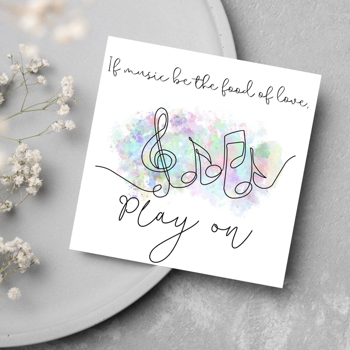 White square card with a one line drawing of musical notes that look like they are dancing in front of a pastel rainbow watercolour cloud. Cursive text reads, If music be the food of love, play on