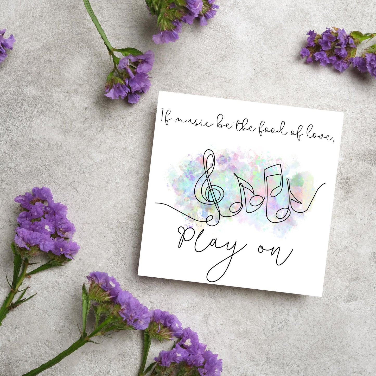 White square card with a one line drawing of musical notes that look like they are dancing in front of a pastel rainbow watercolour cloud. Cursive text reads, If music be the food of love, play on