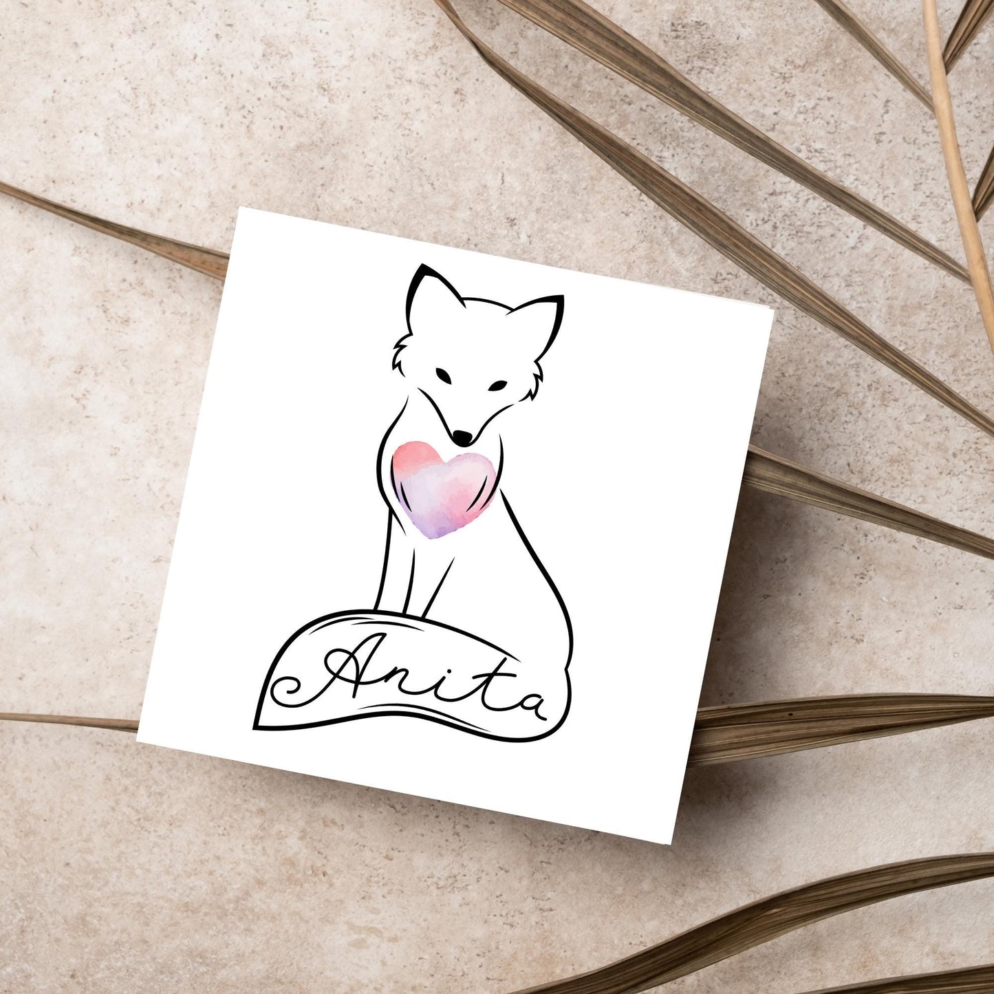 Square card with simple black line drawing of a fox sitting with its tail wrapped around its feet. It has a pink watercolour heart on its chest and personalised with a name on the tail in a calligraphy font