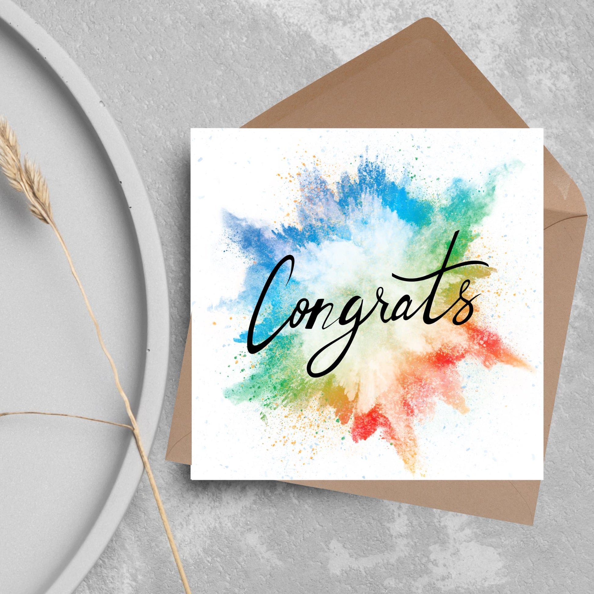 square card with rainbow paint splash against a white background. Black calligraphy style text overlay the paint with congrats