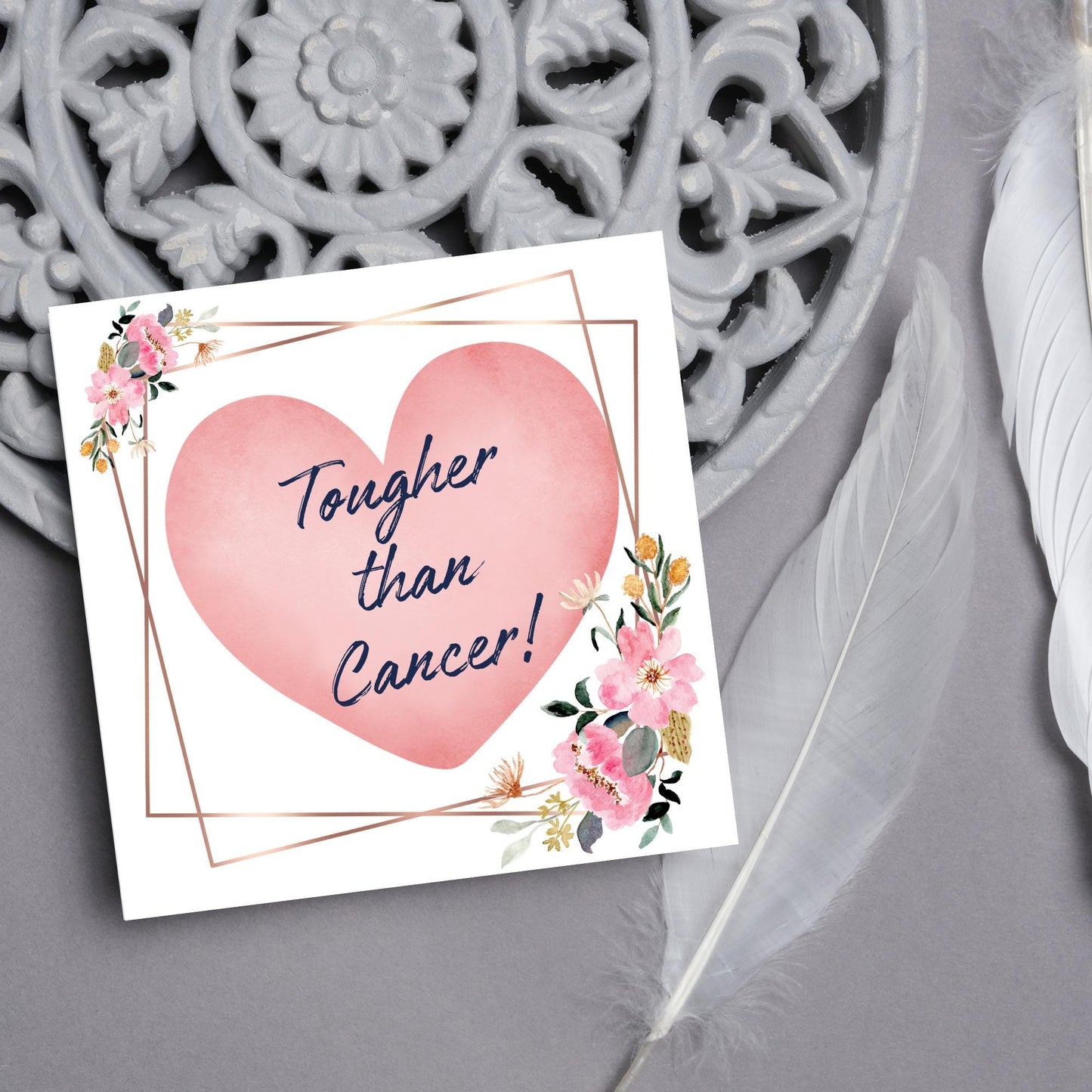 Square white card with a watercolour floral border frame and a pink heart in the centre with the text Tougher than cancer in s handwritten style navy blue font