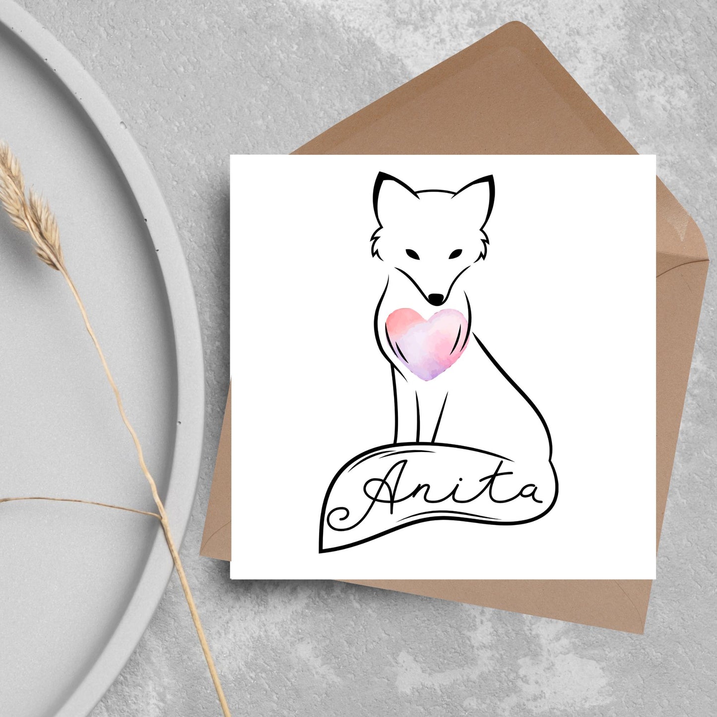 Square card with simple black line drawing of a fox sitting with its tail wrapped around its feet. It has a pink watercolour heart on its chest and personalised with a name on the tail in a calligraphy font